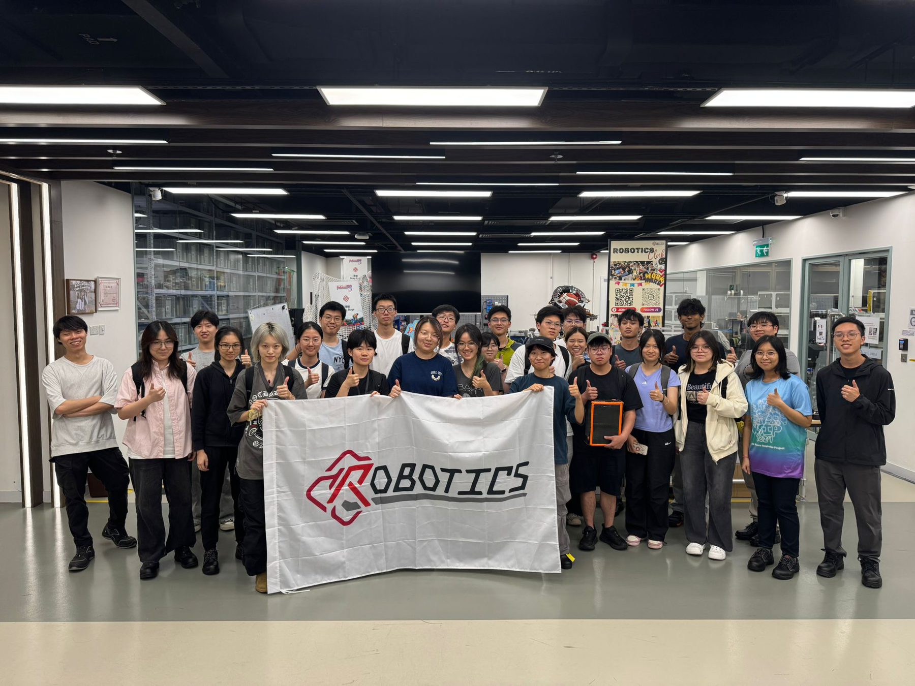 Members holding the PolyU Robotics flag after a training activity
