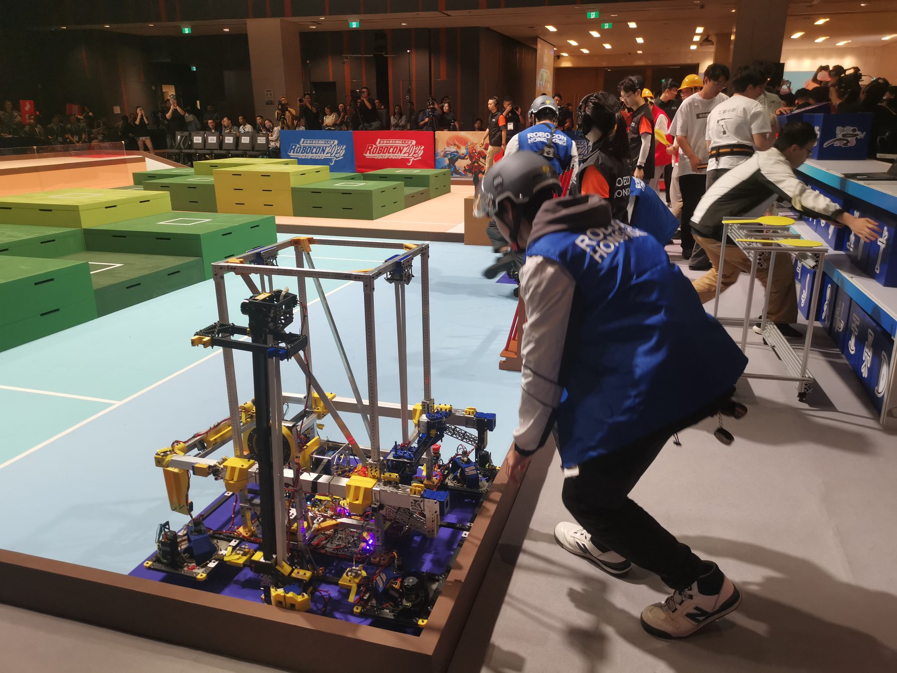 Robocon team members positioning their robot beside the competition field