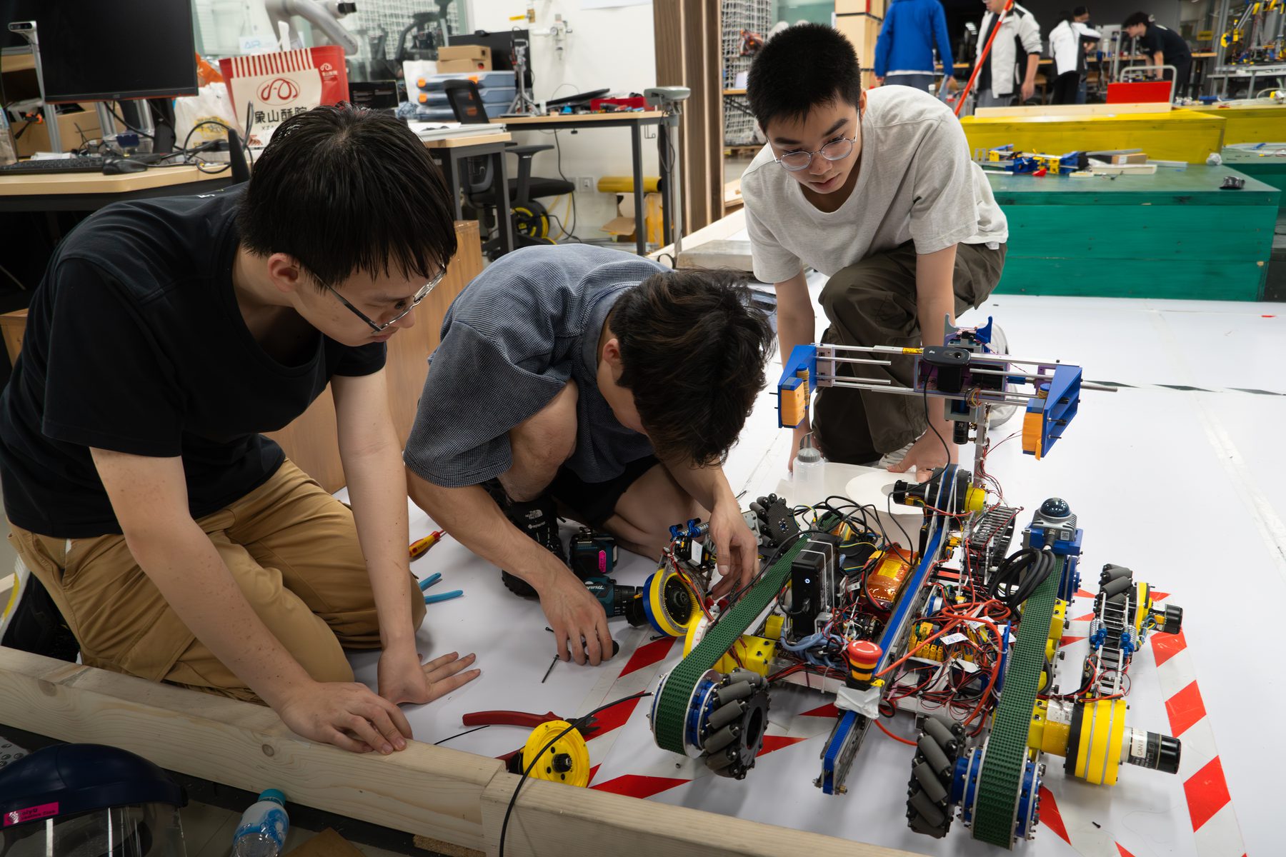 Students checking a Robocon robot during lab preparation