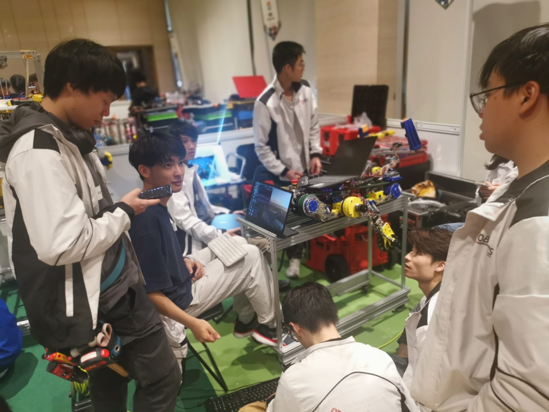 Robocon team members debugging their robot in the pit area