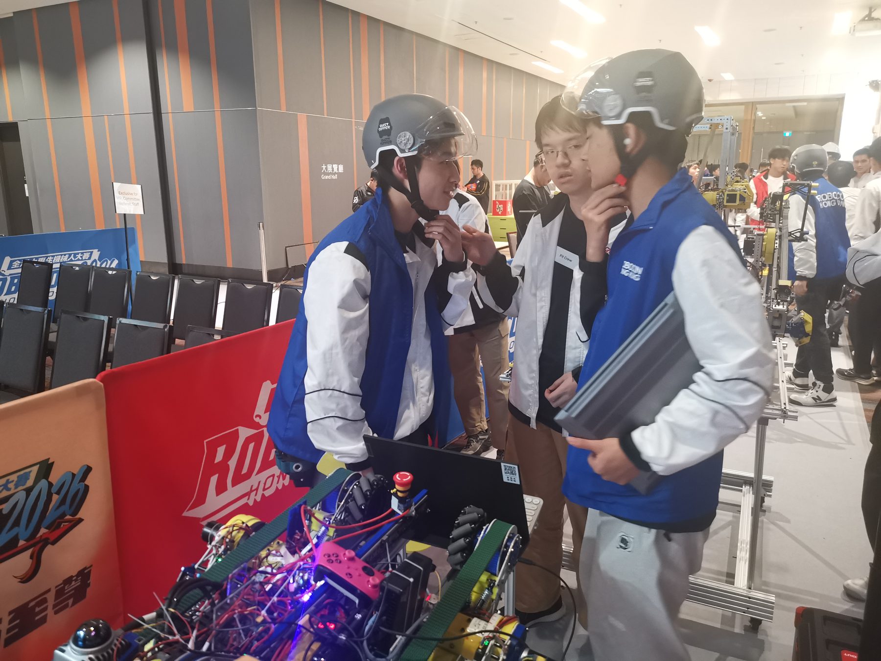 Robocon team members wearing helmets during a pre-match briefing