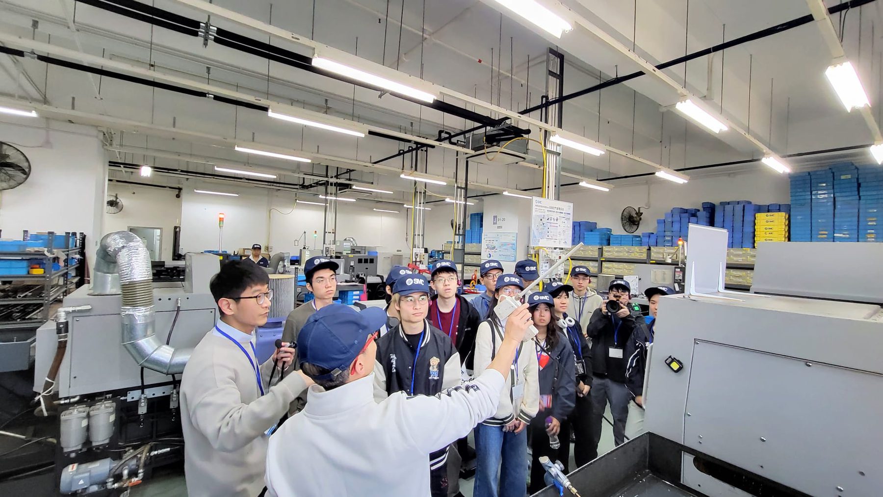 Students observing industrial equipment during an SMC smart factory tour